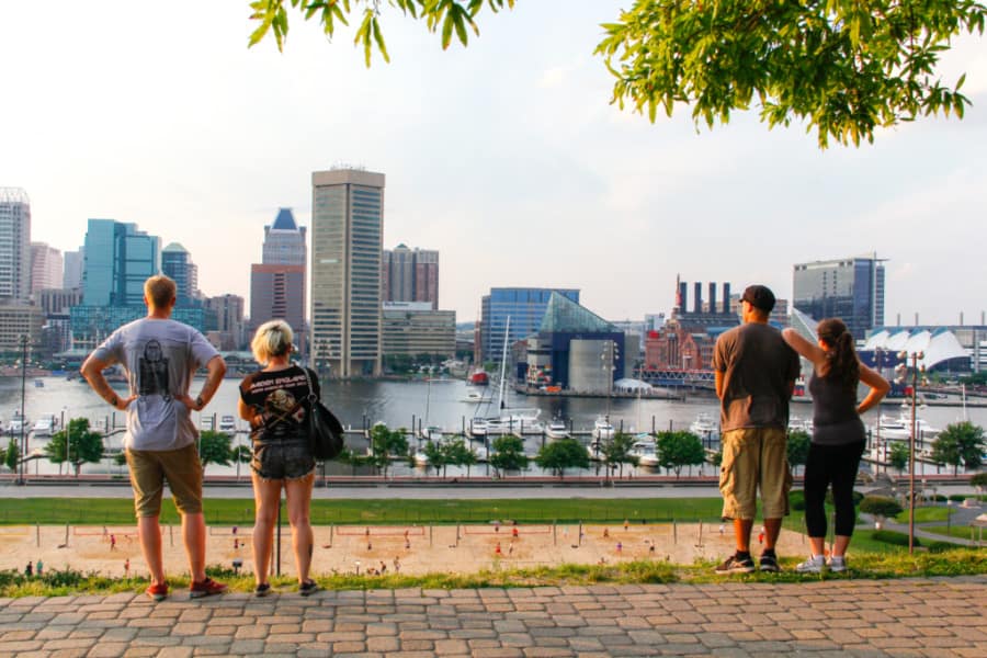 Two couples stand, looking at the Inner Harbor and skyline of Baltimore.